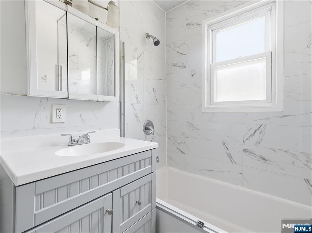 648 Fairview Avenue, Unit 2 Fairview, NJ 07022 - Photo 15 of 17 a bathroom with a sink a vanity and a bathtub