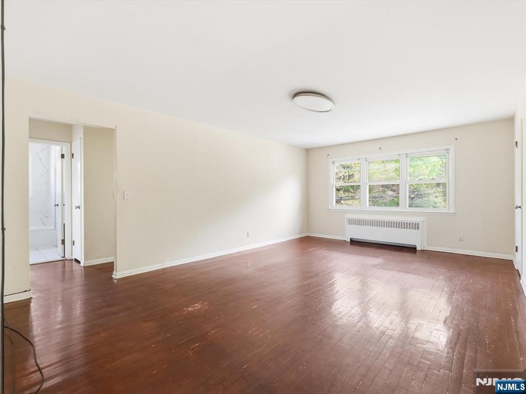 648 Fairview Avenue, Unit 2 Fairview, NJ 07022 - Photo 5 of 17 an empty room with wooden floor and windows
