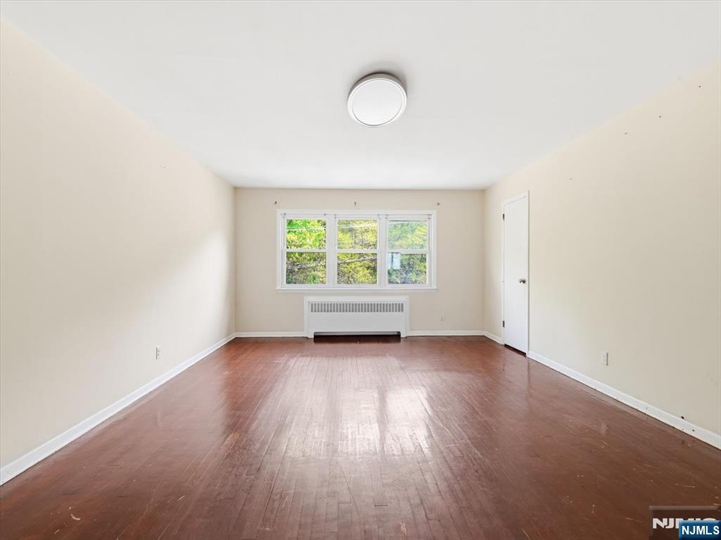 648 Fairview Avenue, Unit 2 Fairview, NJ 07022 - Photo 10 of 17 an empty room with wooden floor and windows