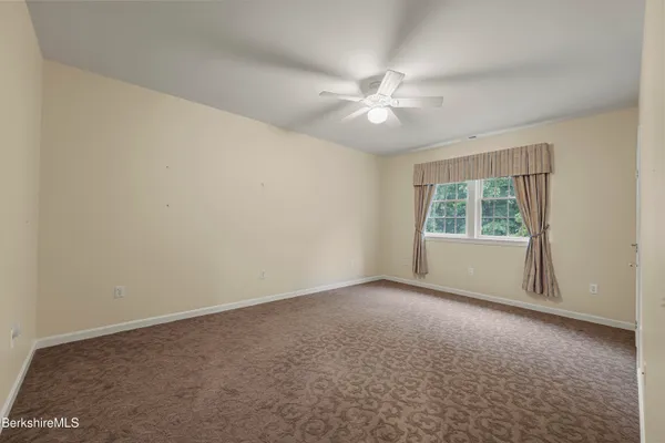 an empty room with a window and a fan