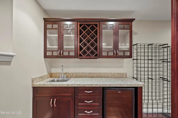 a bathroom with a granite countertop sink a mirror and a shower