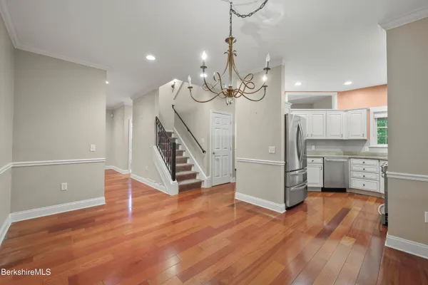 a view of a room with wooden floor and electronic appliances