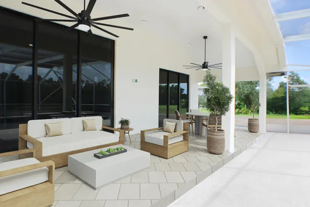 a living room with furniture a chandelier and a floor to ceiling window
