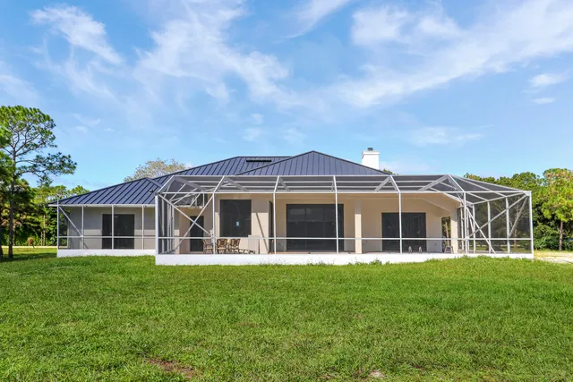 a view of a house with a yard and potted plants