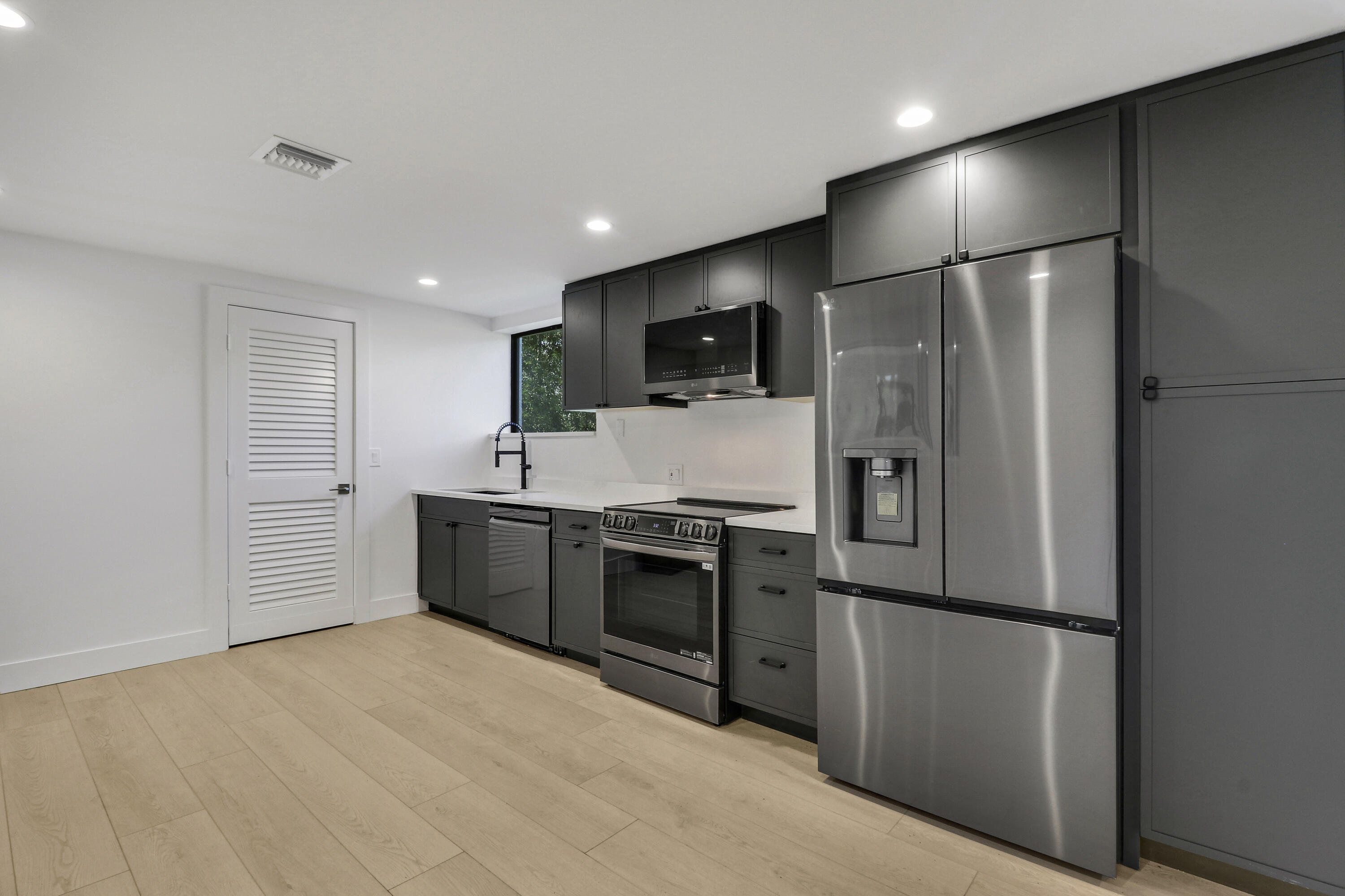 18851 Mack Dairy Road Jupiter, FL 33478 - Photo 27 of 47 a large kitchen with stainless steel appliances a refrigerator and a stove