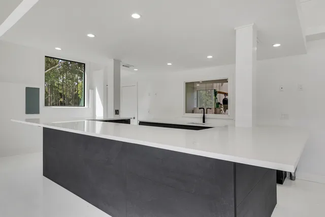 a view of kitchen with stainless steel appliances granite countertop a sink a stove and a window