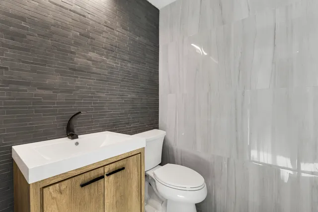 a bathroom with a sink a toilet and mirror