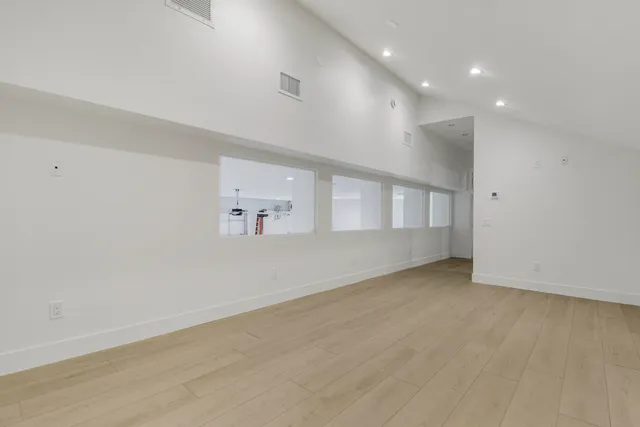 an empty room with cabinet and windows