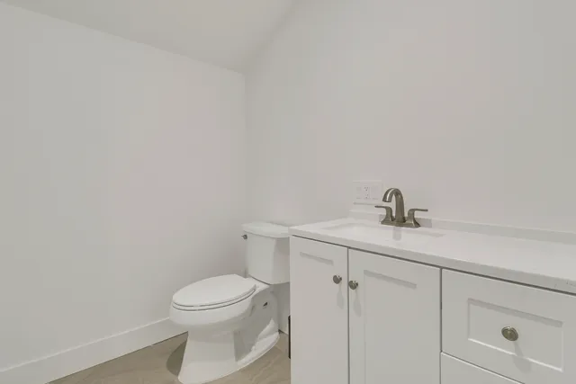 a bathroom with a toilet a sink and mirror