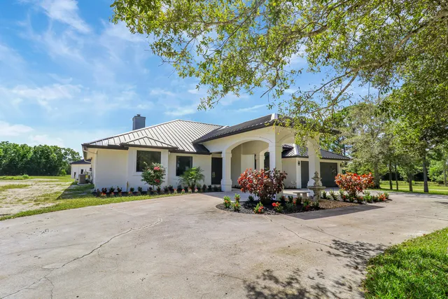 a front view of a house with a garden