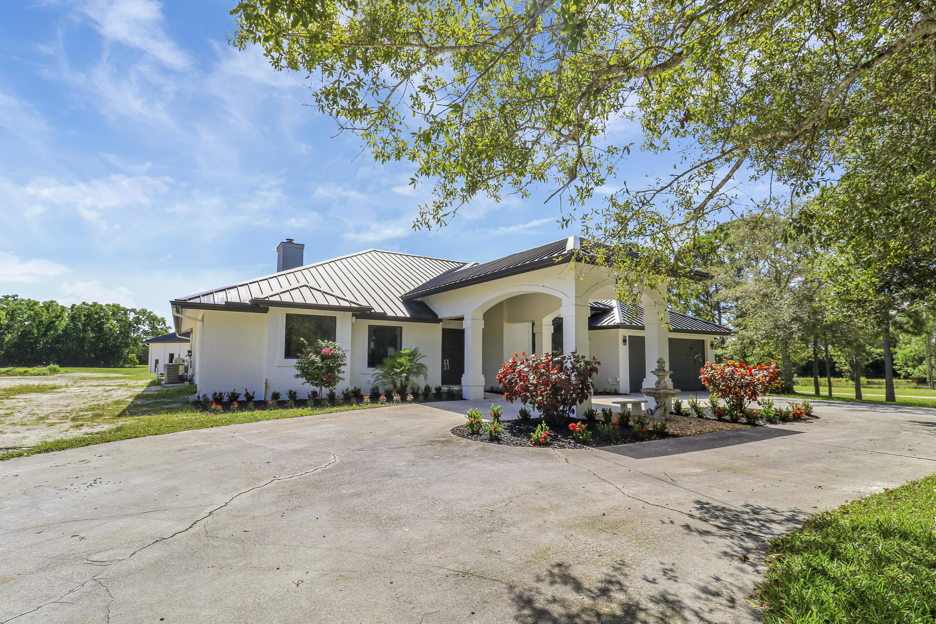18851 Mack Dairy Road Jupiter, FL 33478 - Photo 4 of 47 a front view of a house with a garden