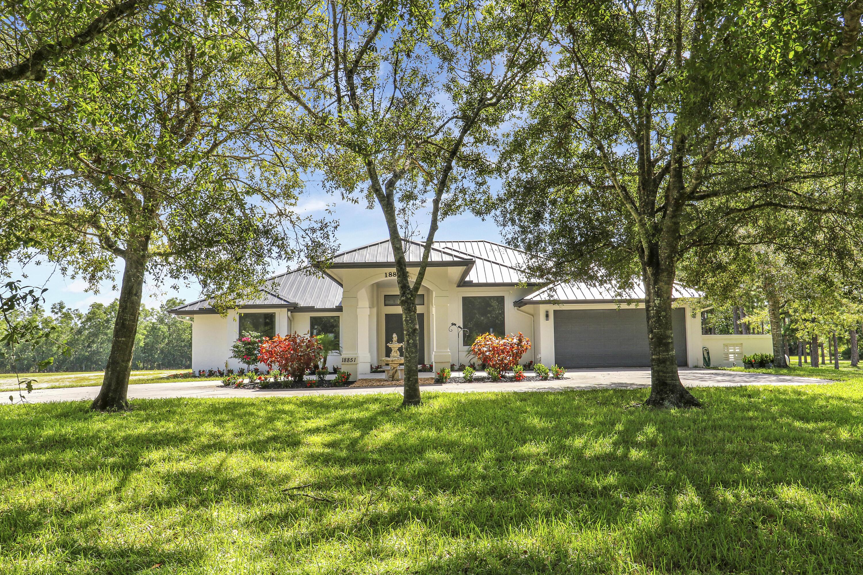 18851 Mack Dairy Road Jupiter, FL 33478 - Photo 5 of 47 a front view of a house with garden