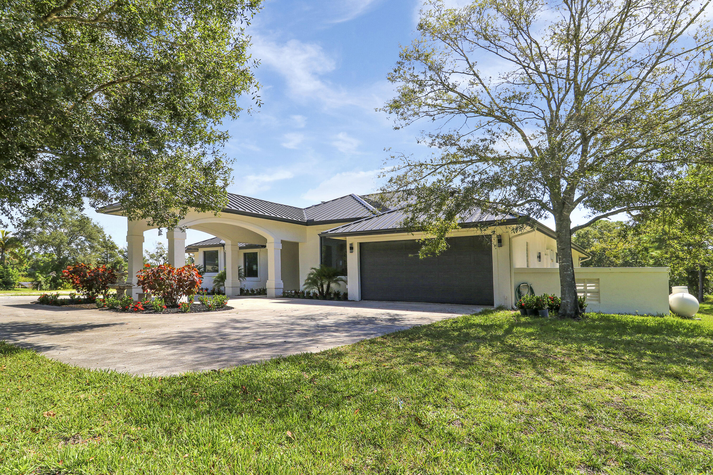 18851 Mack Dairy Road Jupiter, FL 33478 - Photo 6 of 47 a front view of house with yard and trees
