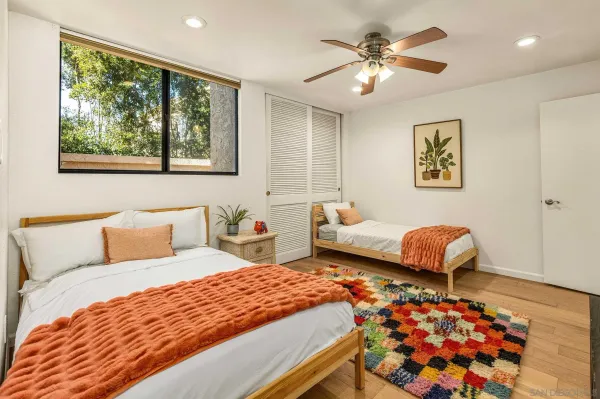 a bedroom with a bed mirror and window