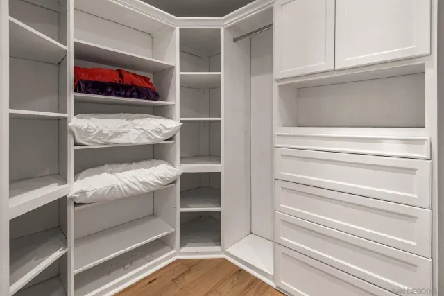 a view of walk in closet with clothes and shoes