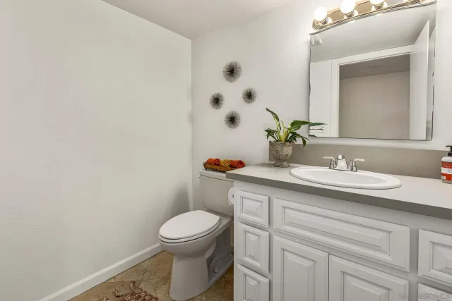 a bathroom with a granite countertop toilet sink and mirror