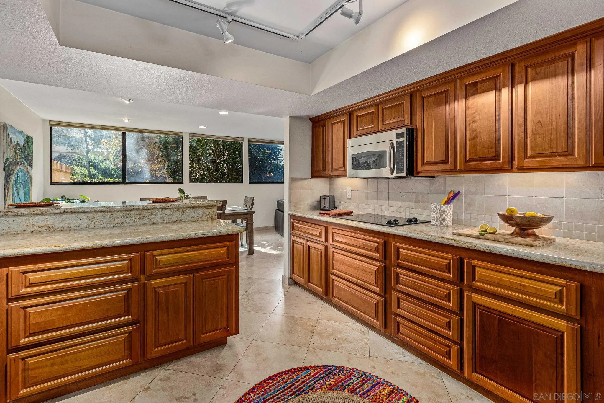 2420 Torrey Pines Road, Unit A104 La Jolla, CA 92037 - Photo 6 of 23 a kitchen with stainless steel appliances granite countertop sink stove and cabinets