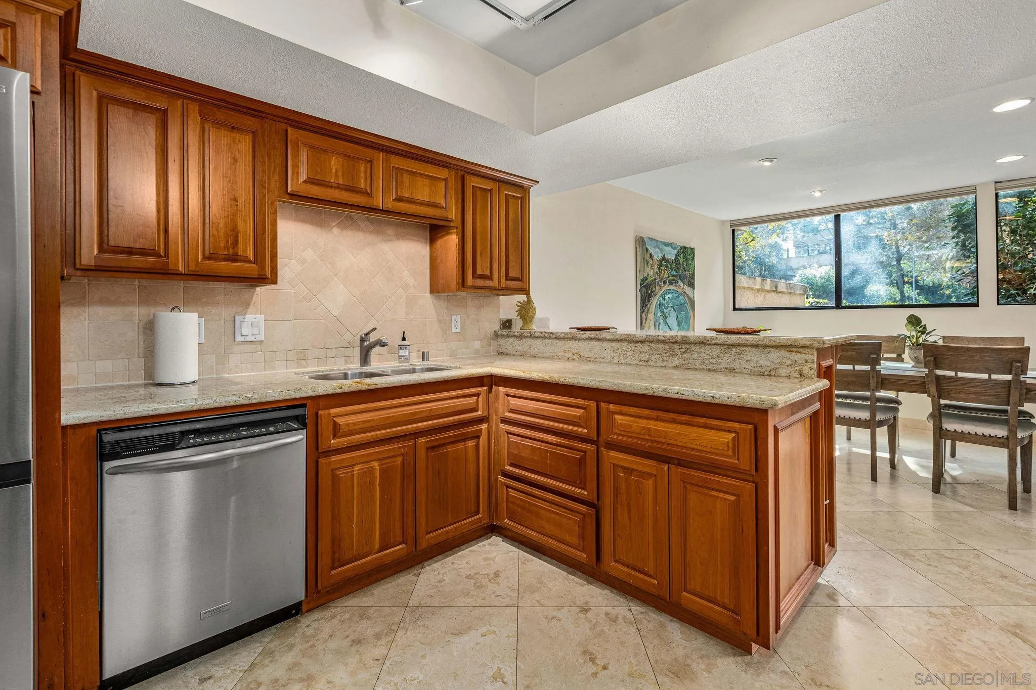2420 Torrey Pines Road, Unit A104 La Jolla, CA 92037 - Photo 7 of 23 a kitchen with stainless steel appliances granite countertop wooden cabinets a sink and a stove