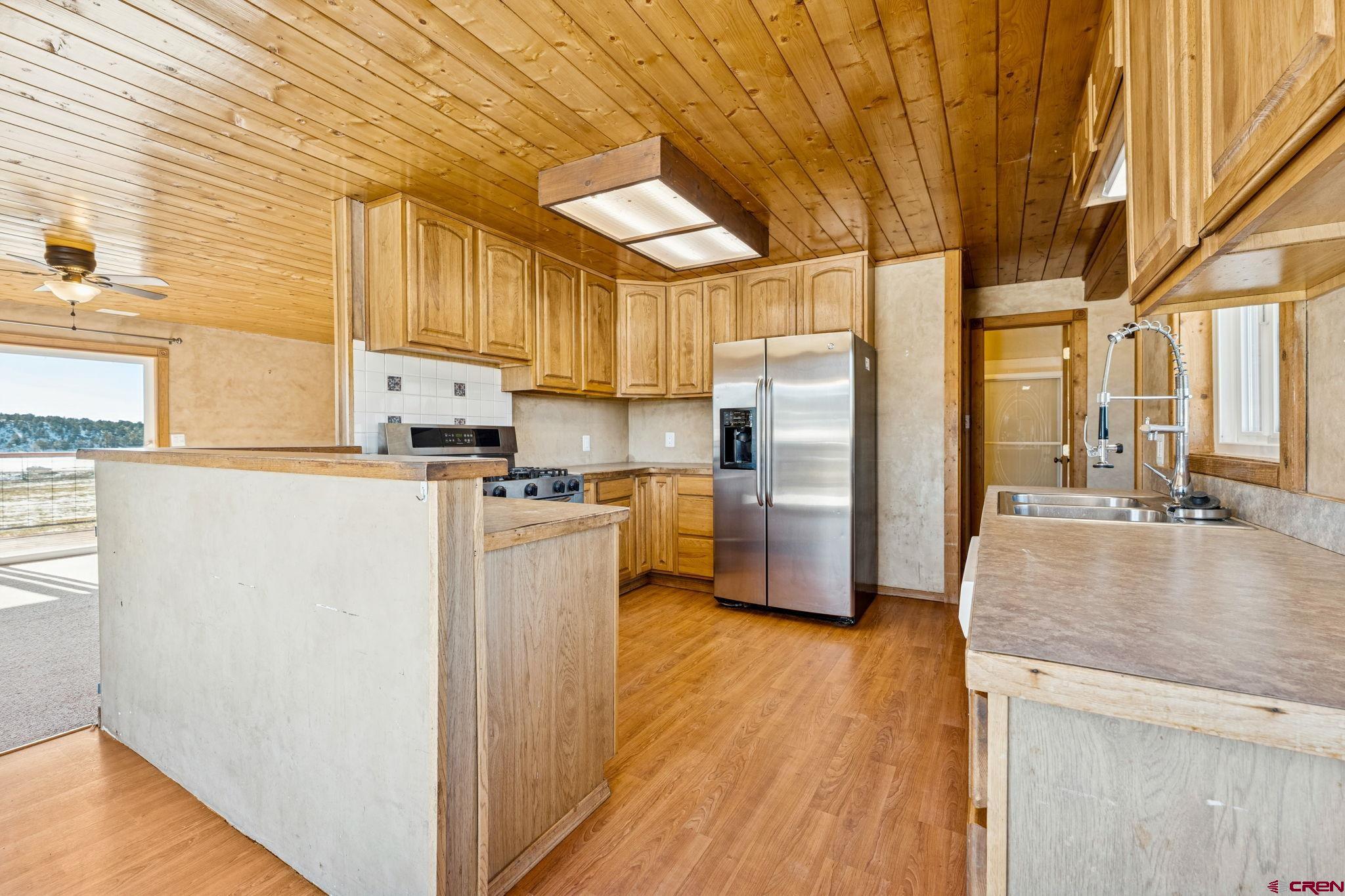 124 Meadow Road Ignacio, CO 81137 - Photo 26 of 37 a kitchen with stainless steel appliances granite countertop a refrigerator a stove and a wooden floors