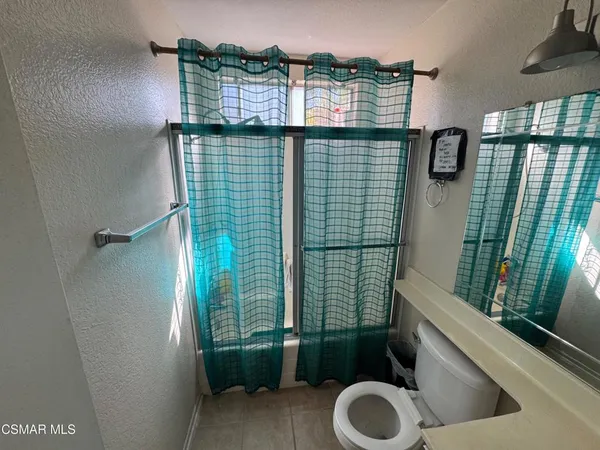 a bathroom with a toilet a sink and a mirror