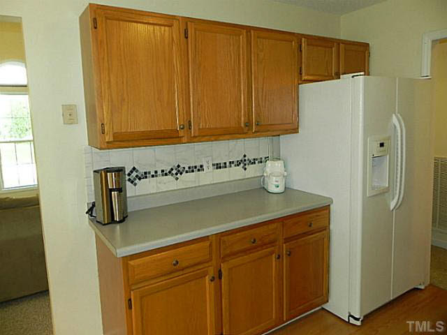 4517 Whistling Way Raleigh, NC 27616 - Photo 11 of 24 a kitchen with a refrigerator and cabinets