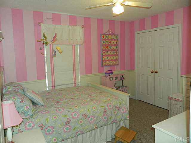 4517 Whistling Way Raleigh, NC 27616 - Photo 20 of 24 a bedroom with a bed and a chandelier