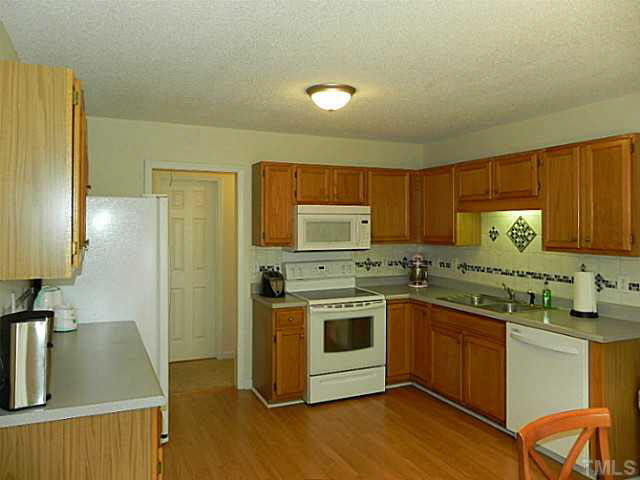 4517 Whistling Way Raleigh, NC 27616 - Photo 9 of 24 a kitchen with a sink stove and refrigerator