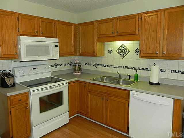 4517 Whistling Way Raleigh, NC 27616 - Photo 10 of 24 a kitchen with a sink stove top oven and cabinets