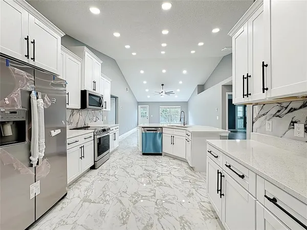 a kitchen with stainless steel appliances granite countertop a stove a refrigerator and a microwave