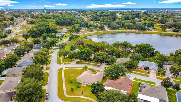 an aerial view of residential houses with swimming pool and lake view