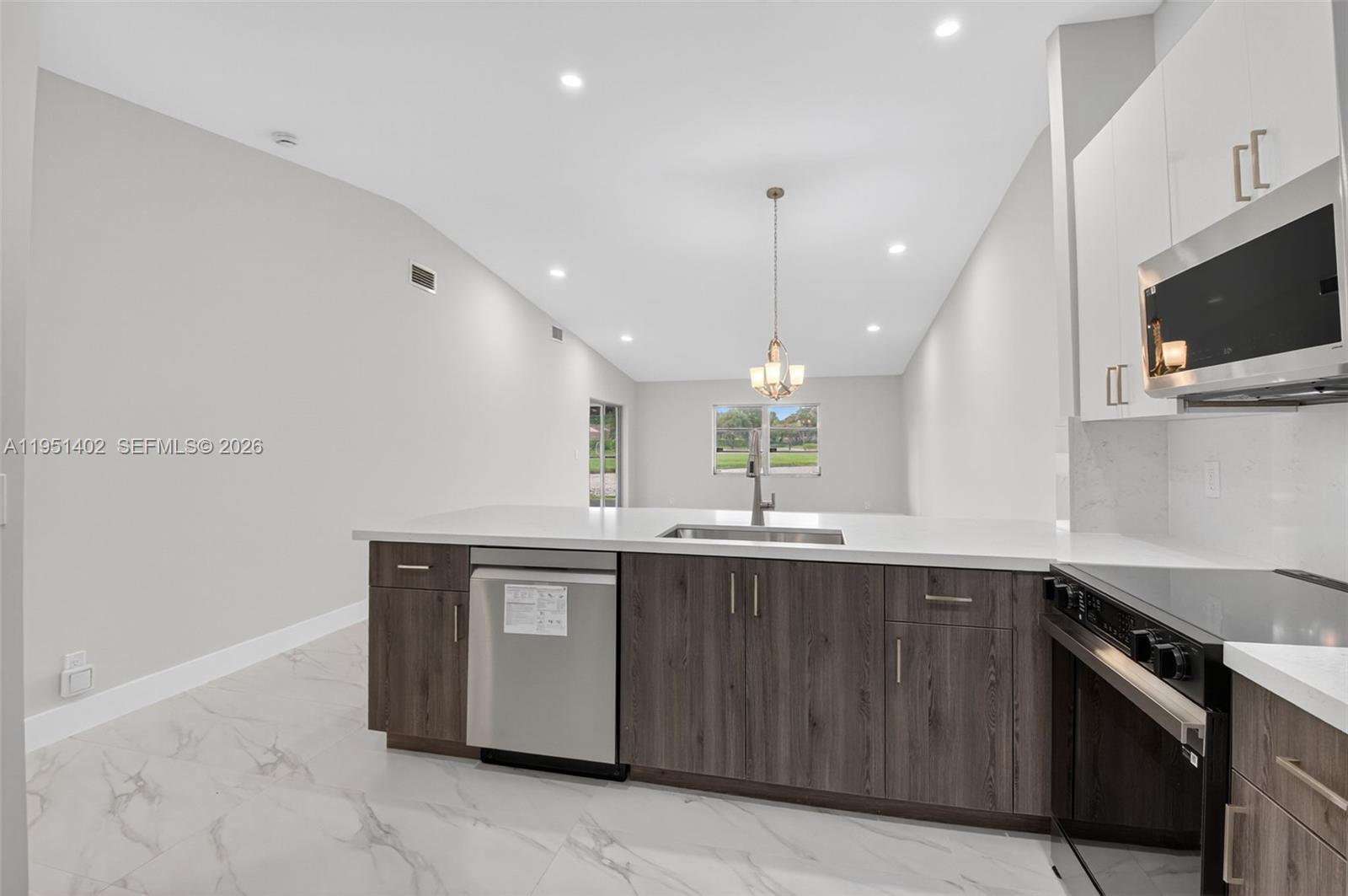 8127 Songbird Terrace Boca Raton, FL 33496 - Photo 17 of 65 a kitchen with stainless steel appliances granite countertop a sink and a microwave