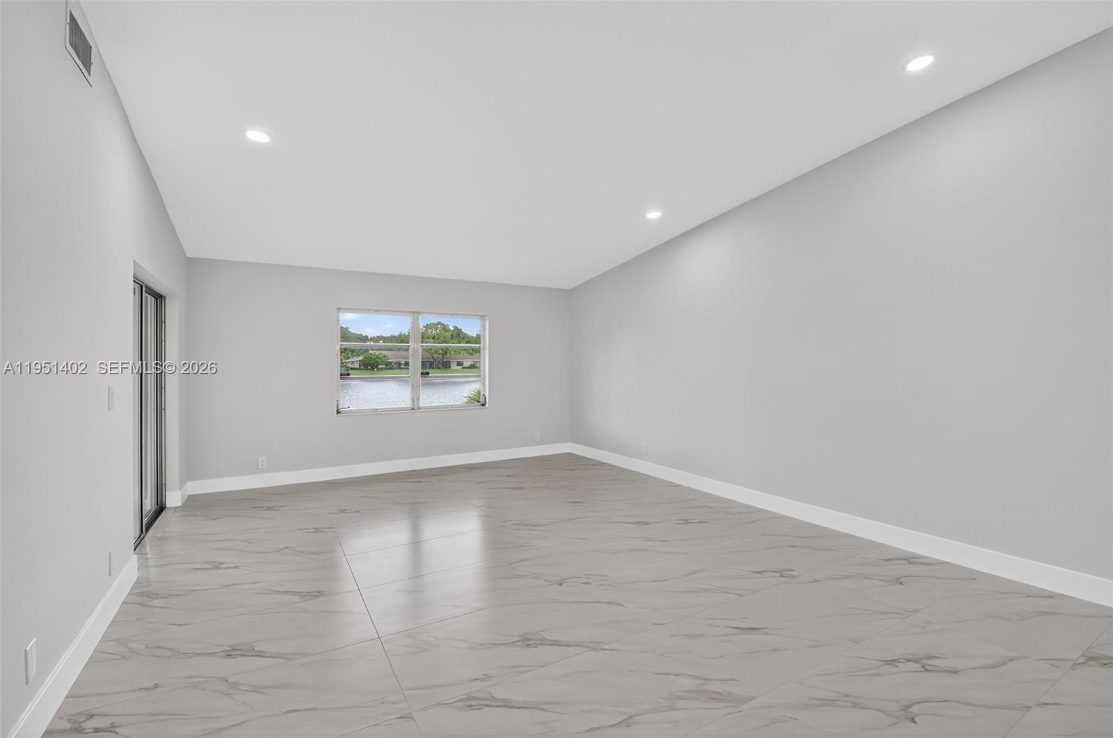 8127 Songbird Terrace Boca Raton, FL 33496 - Photo 10 of 65 an empty room with wooden floor and windows