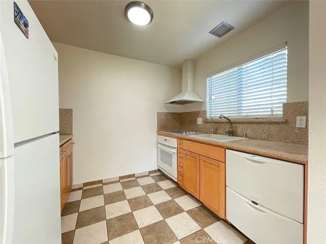 a kitchen with granite countertop stainless steel appliances a sink and a cabinets
