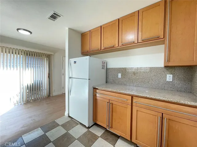 a kitchen with a refrigerator sink and cabinets
