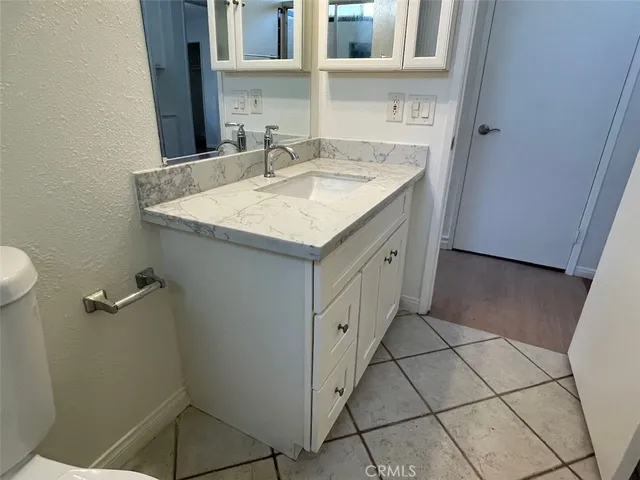 a bathroom with a granite countertop sink and a mirror