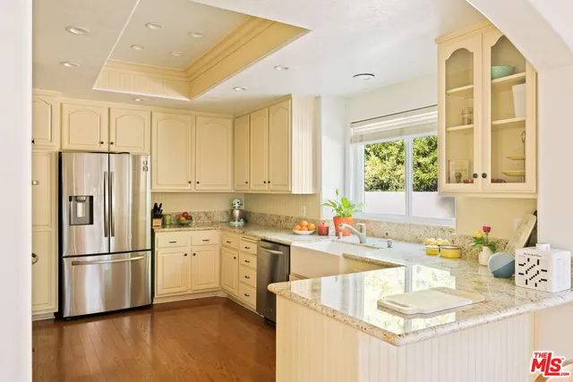 a kitchen with granite countertop a sink appliances a counter top space and windows
