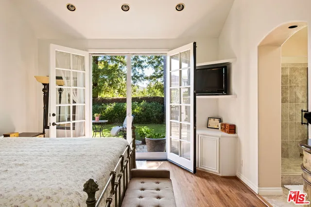 a bedroom with a bed and a flat screen tv