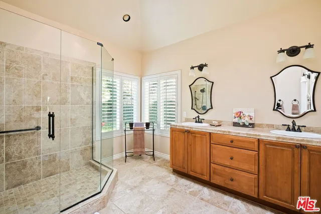 a spacious bathroom with double vanity a mirror a bathtub and shower