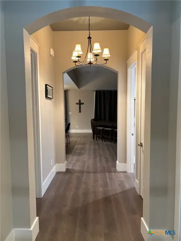 a view of a hallway with chandelier and front door