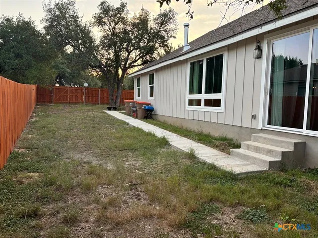 a view of a backyard with wooden fence