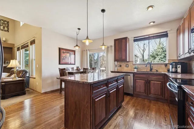 a kitchen with stainless steel appliances granite countertop sink stove top oven and refrigerator