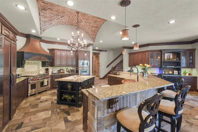 a large kitchen with granite countertop a stove and a sink
