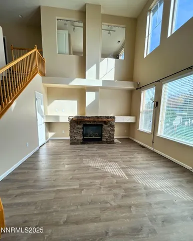 a view of kitchen and empty room with wooden floor