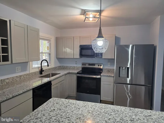 a kitchen with kitchen island a sink stainless steel appliances and cabinets