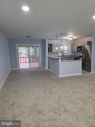 a view of an empty room with windows & cabinet