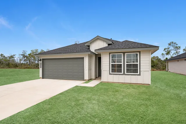 a front view of a house with a garden and yard