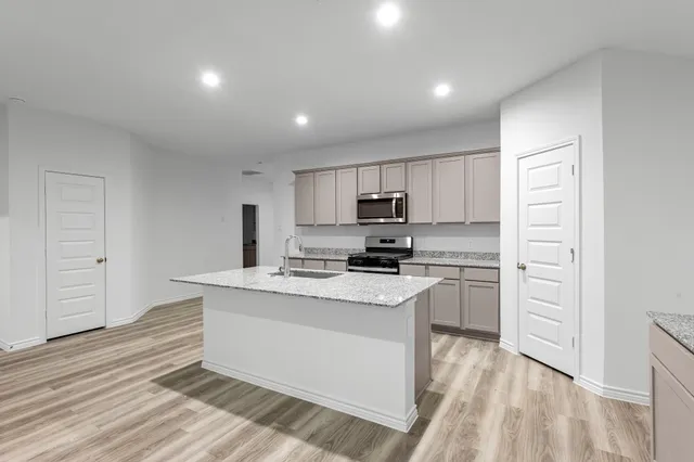 a kitchen with kitchen island a sink appliances and cabinets