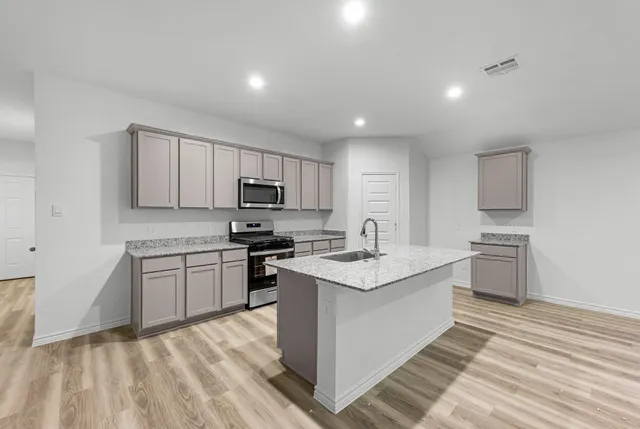a kitchen with a sink stove top oven and refrigerator