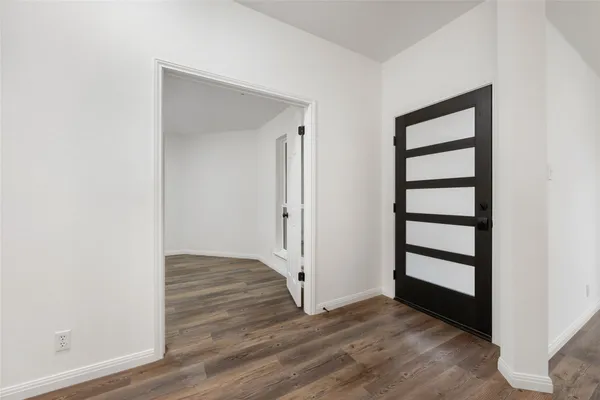 a view of a hallway with wooden floor