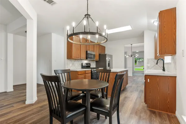 a kitchen with stainless steel appliances wooden cabinets and a stove top oven